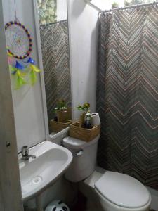 La salle de bains est pourvue de toilettes blanches et d'un lavabo. dans l'établissement Inti Hostel Airport, à Lima