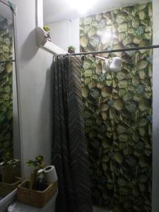 La salle de bains est pourvue d'une douche et d'un mur en pierre. dans l'établissement Inti Hostel Airport, à Lima