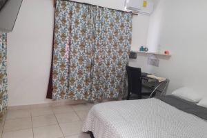 a bedroom with a bed and a curtain with a desk at Casa Familiar en Cluster Privado. in Veracruz