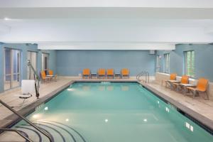 een zwembad in een hotelkamer met stoelen en tafels bij Holiday Inn Express Haskell-Wayne Area, an IHG Hotel in Haskell
