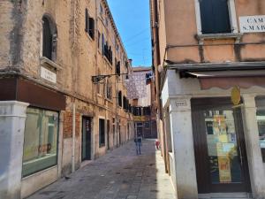 una persona caminando por una calle en un callejón en Suite Doge Marcello, en Venecia