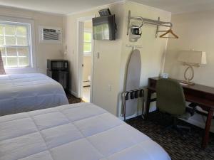 a bedroom with a bed and a desk at Villager Motel in Williamstown