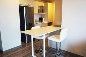a kitchen with a table and two white chairs at Amazing views SJO, Cozy, Equipped. 24/7 Concierge in San José