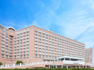 a large pink hotel building with a blue sky at Grand Nikko Tokyo Bay Maihama in Tokyo