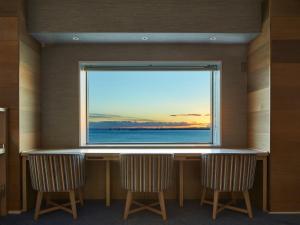 a chair sitting in front of a window with a view of the ocean at Grand Nikko Tokyo Bay Maihama in Tokyo