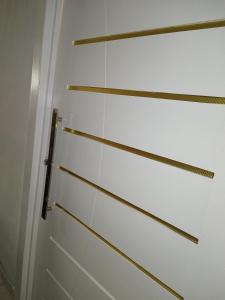 een badkamer met witte muren en gouden strepen aan de muur bij Apartamentos aconchegantes in Teresina