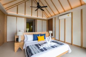a bedroom with a large bed with blue and yellow pillows at KC Grande Resort Koh Chang in Ko Chang