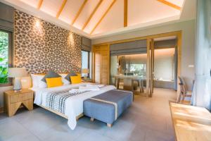 a bedroom with a large bed with a blue ottoman at KC Grande Resort Koh Chang in Ko Chang