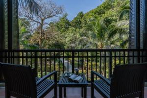 a balcony with two chairs and a table and trees at KC Grande Resort Koh Chang in Ko Chang