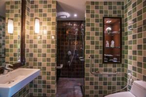 a green tiled bathroom with a sink and a shower at KC Grande Resort Koh Chang in Ko Chang