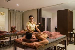 a woman giving a man a massage on a bed at KC Grande Resort Koh Chang in Ko Chang