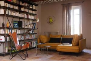 salon z żółtą kanapą i półkami na książki w obiekcie la maiZon w mieście Mazan