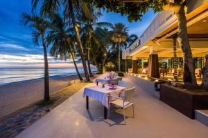 a dining table on the beach at dusk at KC Grande Resort Koh Chang in Ko Chang