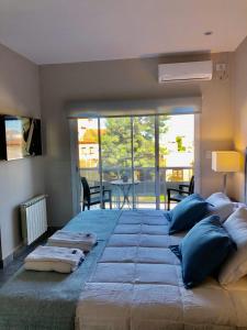 a large bed with blue pillows in a bedroom at Duplex Charm in Salta