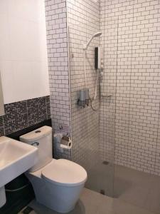 a bathroom with a toilet and a glass shower at The Phu Resort in Pran Buri