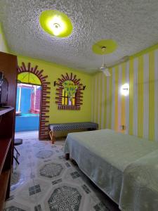 - une chambre avec un lit et un mur jaune dans l'établissement Hotel Villa Luz, à Puerto Escondido