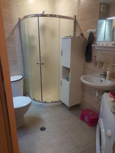 a bathroom with a shower and a toilet and a sink at Byala COZY APARTMENT in Byala
