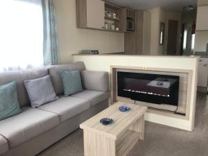 a living room with a couch and a flat screen tv at Hoburne Beach Escape near Christchurch in Mudeford