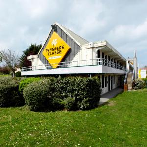 una casa con un cartel amarillo encima en Premiere Classe St Etienne Nord Villars en Villars