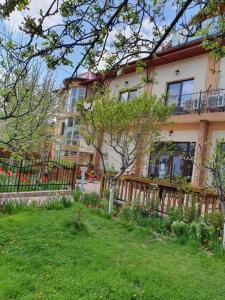 een huis met een hek voor een tuin bij PENSIUNEA CIREȘUL ALB in Tulcea
