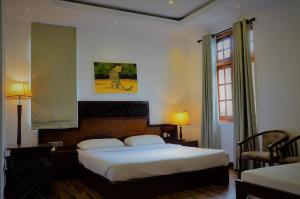 una camera d'albergo con letto e finestra di Heaven Seven Nuwara Eliya a Nuwara Eliya