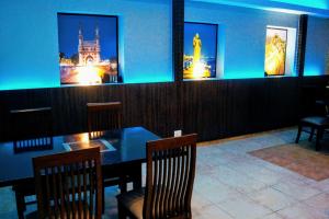 a dining room with a table and chairs and pictures at Vasco Residency in Vasco Da Gama