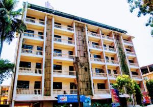 a tall yellow building with white balconies at Vasco Residency in Vasco Da Gama