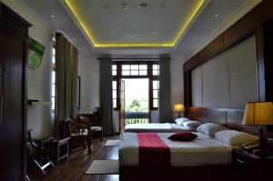 a hotel room with two beds and a large window at Heaven Seven Nuwara Eliya in Nuwara Eliya