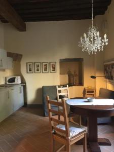 eine Küche und ein Esszimmer mit einem Tisch und einem Kronleuchter in der Unterkunft Casina Bella in Cortona