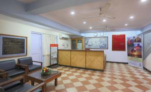 a waiting room with a table and chairs and a counter at Miramar Residency in Panaji