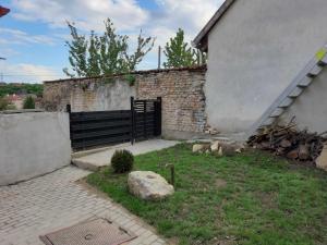um edifício de tijolos com um portão num quintal em Sarló utcai ház em Veszprém