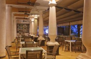 a dining room with tables and chairs and columns at Calangute Residency in Calangute