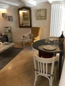 a living room with a table and chairs and a dog at La 54 Provence in L'Isle-sur-la-Sorgue