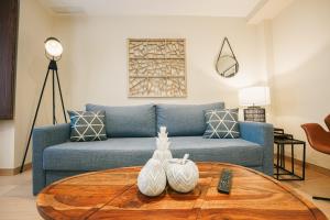 a living room with a blue couch and a table at Debambú Atarazanas in Málaga