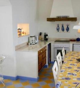 een keuken met een aanrecht en een tafel met stoelen bij Casa da Praia in Albufeira