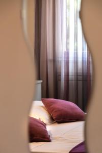 a bed with two pillows in front of a window at Oasi Hotel in Levanto