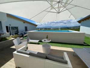 a patio with two couches and an umbrella at TheVilla holiday in Silvi Marina
