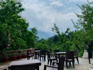 a group of tables and chairs sitting on a patio at Jungle by sturmfrei Manali in Manāli