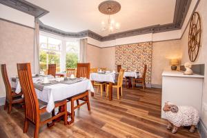 a dining room with tables and a sheep on the floor at Lynwood Guest House in Keswick