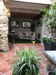 un patio con sofá, mesa y algunas plantas en La 54 Provence en LʼIsle-sur-la-Sorgue