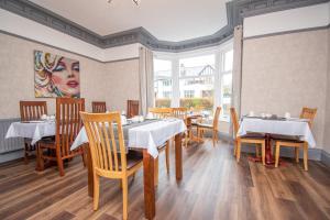 a restaurant with tables and chairs and a painting on the wall at Lynwood Guest House in Keswick