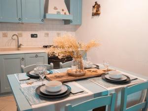 una cocina con una mesa con platos y vasos. en IL GRECALE - ConfirentHouse en Corniglia