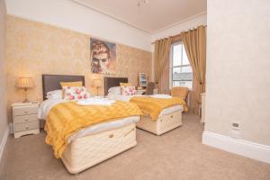 a bedroom with two beds and a painting on the wall at Lynwood Guest House in Keswick