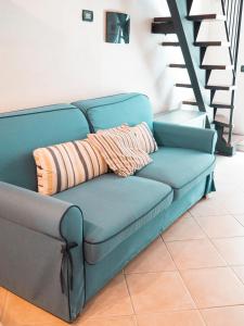 柯爾尼利亞的住宿－IL GRECALE - ConfirentHouse，蓝色的沙发,配有两个枕头