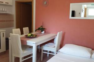 ein Esszimmer mit einem weißen Tisch und Stühlen in der Unterkunft Flowers house on the island in Žman