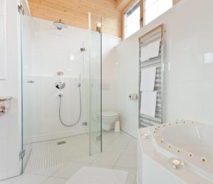 biała łazienka z prysznicem i wanną w obiekcie Hotel Lärchenhof Natur w mieście Seefeld in Tirol +37 zdjęć