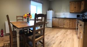 a kitchen with a table with a vase of flowers on it at Strone in Boath