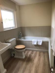 a bathroom with a tub and a toilet and a sink at Strone in Boath