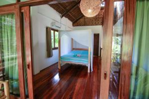 
a bedroom with a bed and a window at Surfing Carabao Beach Houses in General Luna
