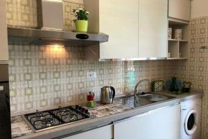 una cucina con lavello e fornello forno superiore di Blue Daisy Apartment a Rapallo